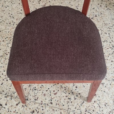 כיסא עם מושב מרופד וכלי ניקוי על הרצפה