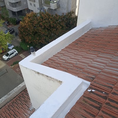 גג רעפים עם איטום לבן לאורך הקצוות