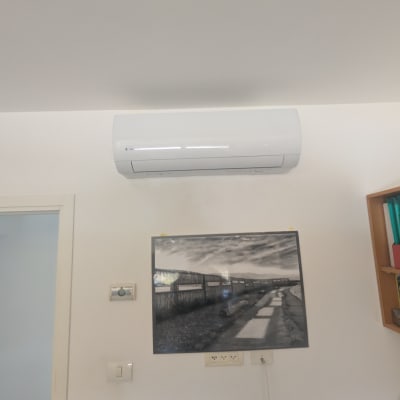 מזגן מותקן על קיר בחדר עם תמונה