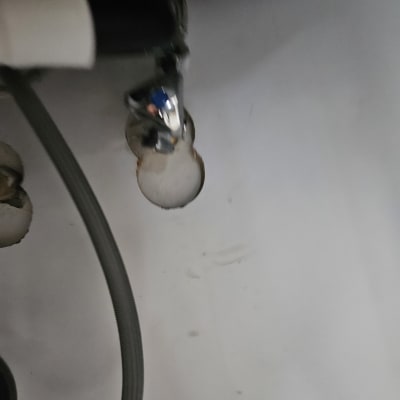 צינור מתכת מתחת לכיור עם חיבורים