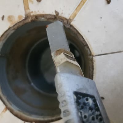 סכין יפנית ליד פתח ניקוז ברצפה