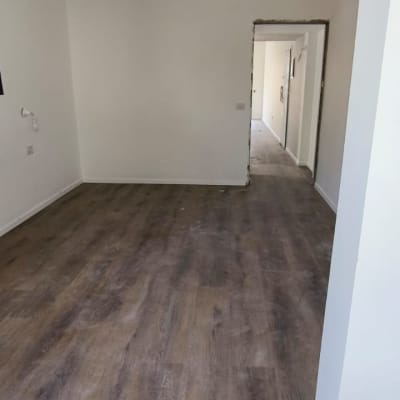 חדר עם רצפת פרקט כהה ודלת פתוחה