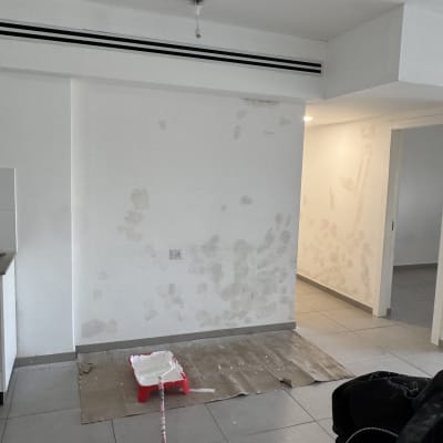 קיר עם תיקוני צבע וכלי עבודה לצביעה