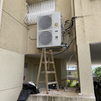 יחידת מיזוג אוויר מותקנת על קיר חיצוני עם סולם