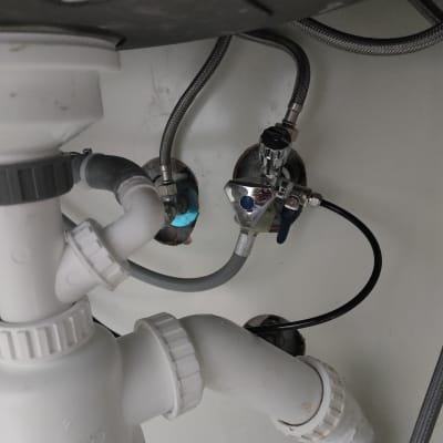 צינורות מתחת לכיור עם חיבורים וברזים