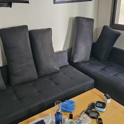 ספה עם כריות וכלי ניקוי על שולחן