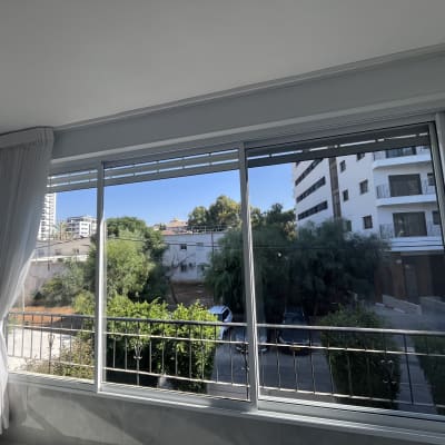 חלון נקי עם וילון לבן ונוף חיצוני