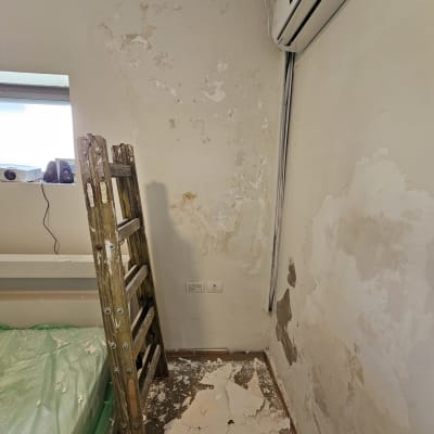 קיר מתקלף עם סולם ועבודות תיקון צבע