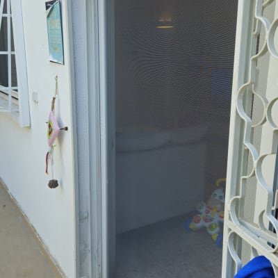 דלת עם רשת נגד יתושים ומגבת תלויה