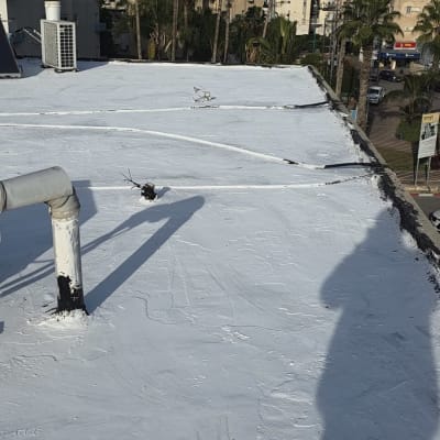 גג אטום עם חומר איטום לבן, צינור וצל של אדם