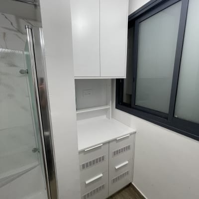 ארון לבן עם מגירות ליד חלון זכוכית