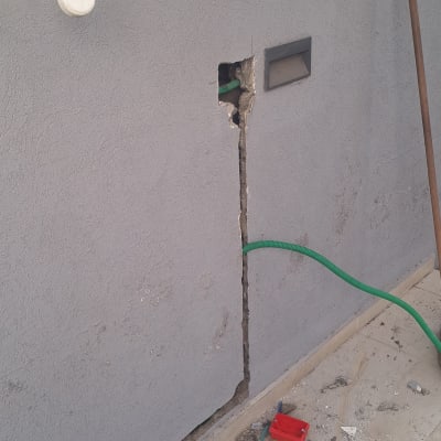 עבודות חשמל בקיר עם כלים וחוטים חשמליים