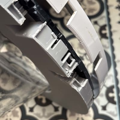 חלק פלסטיק שבור עם רקע של רצפה מעוצבת