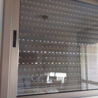 תריסים סגורים על חלון עם מסגרת מתכתית