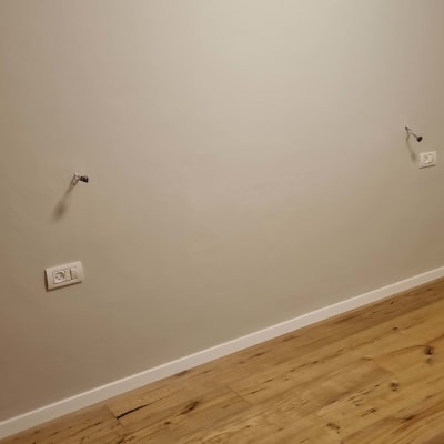 רצפת פרקט עם קיר לבן ושקעי חשמל