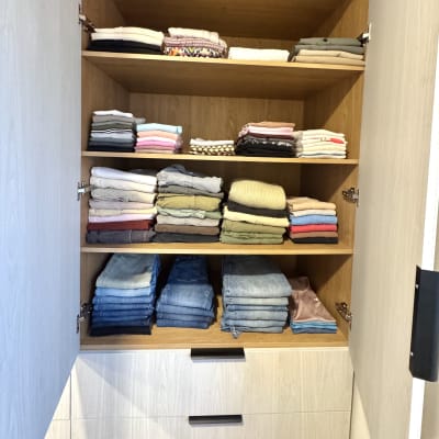 בגדים מקופלים בארון עץ עם מדפים פתוחים