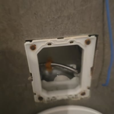 תמונה של קיר עם חור וציוד אינסטלציה