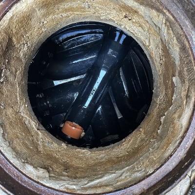 צינור בתוך פתח ביוב, קשור למשאית ואקום