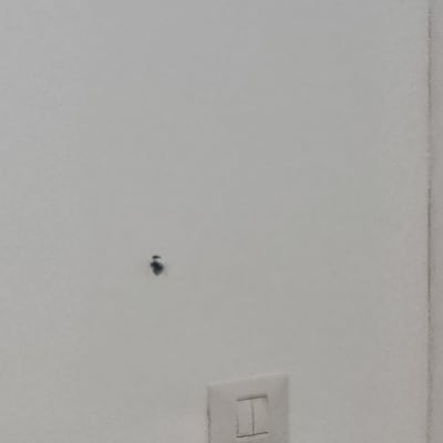 קיר עם שקע חשמל וחור קטן