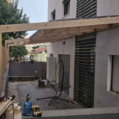 בניית פרגולה מעץ ליד בניין מגורים