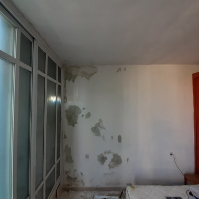 הכנת קיר וקילוף צבע רופף לקראת צביעה בחדר מרוהט
