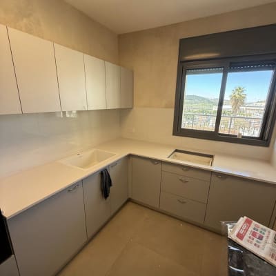 מטבח עם משטחי שיש וחלון גדול