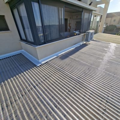 גג פרגולה עם חלונות זכוכית ומזגן חיצוני