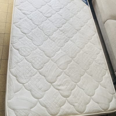 מזרן לבן על רצפה ליד ספה