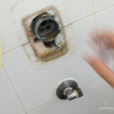 ברז מים עם צינור צהוב על קיר לבן