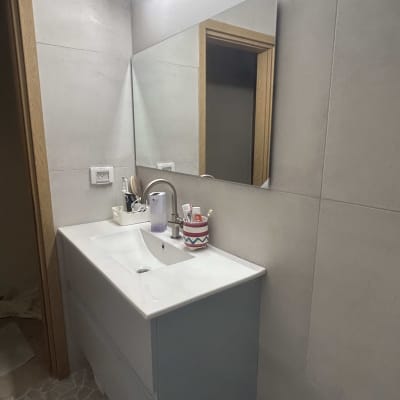 כיור חדש עם מראה ותאורה בחדר אמבטיה