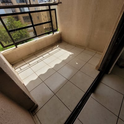 מרפסת עם רצפת אריחים נקייה וצל חלקי