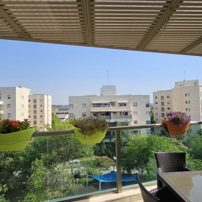 פרגולה מאלומיניום מעל מרפסת עם עציצים