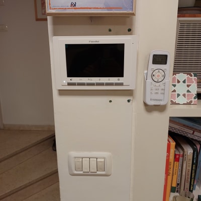 מסך אינטרקום מותקן על קיר לבן