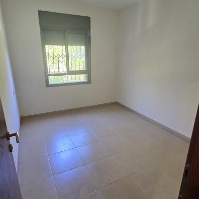 חדר ריק עם חלון ורצפת אריחים