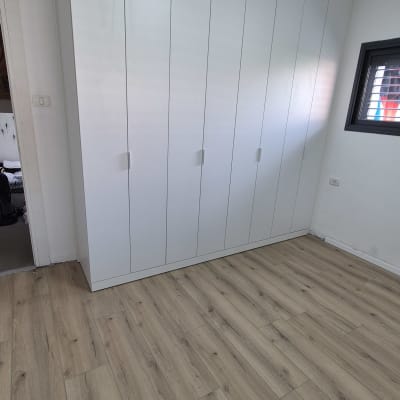 ארון בגדים לבן עם דלתות עץ בחדר שינה