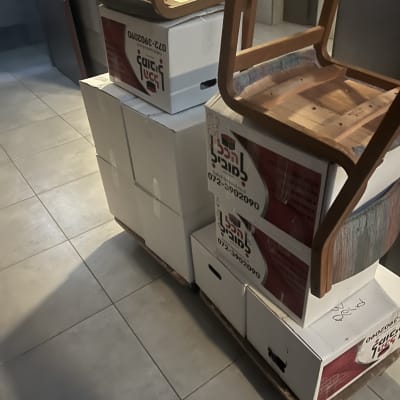 ארגזים ומושבים על משטח, כנראה במהלך מעבר דירה