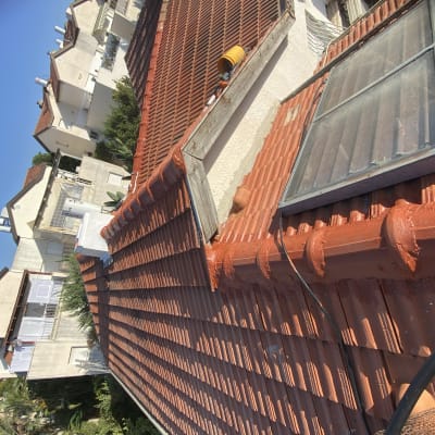 גג רעפים אדום עם קולטי שמש וחוטים