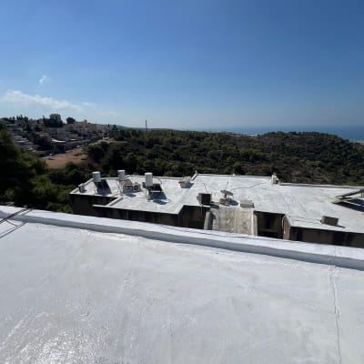 גג אטום בלבן עם דודי שמש ומזגנים