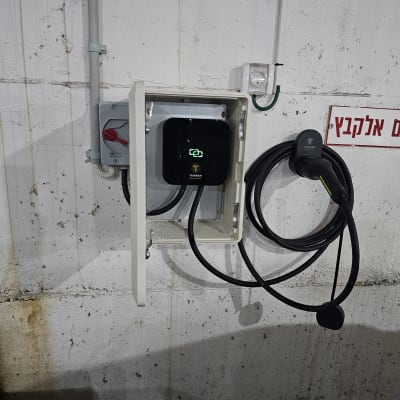 עמדת טעינה לרכב חשמלי מותקנת על קיר בטון