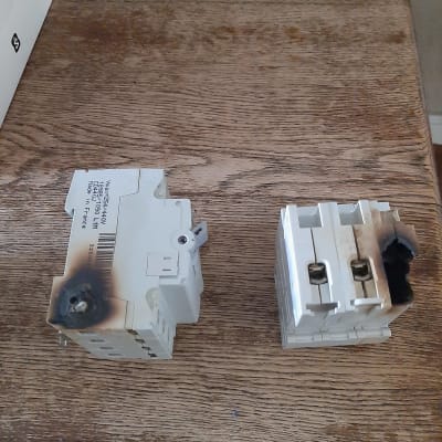 שני מפסקים חשמליים שרופים על שולחן עץ