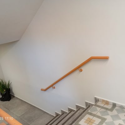 מעקה כתום על קיר לבן במדרגות