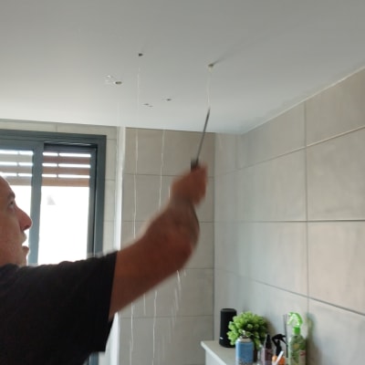 אדם מתקן תקרה עם כלי עבודה