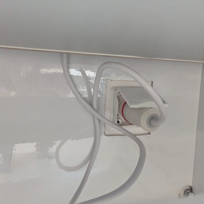 שקע חשמלי עם כבל לבן מחובר לקיר