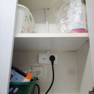 שקע חשמל עם תקע מחובר בארון מטבח