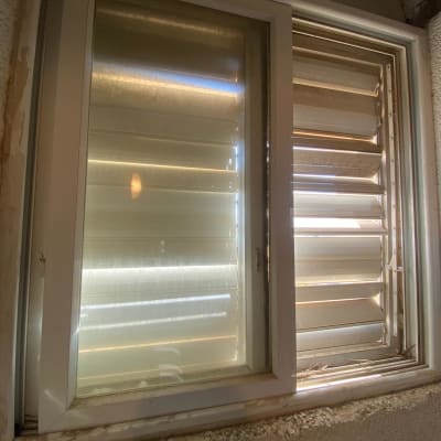 תריסים לבנים פתוחים למחצה בחלון