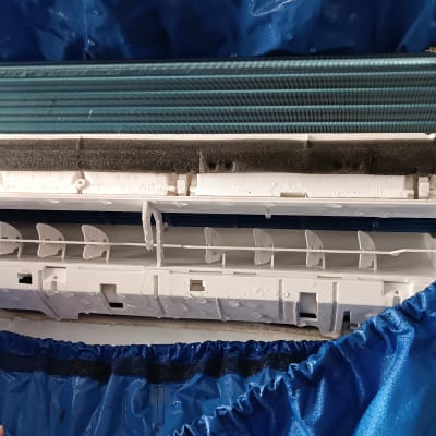 מזגן מפורק עם כיסוי כחול לניקוי