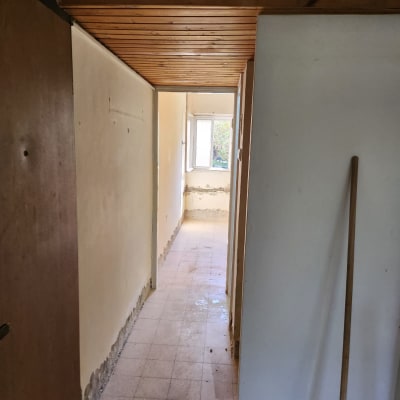 מסדרון עם קירות מתקלפים ורצפה חשופה