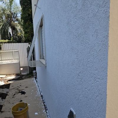 קיר צבוע מחדש עם דלי צבע צהוב על הרצפה