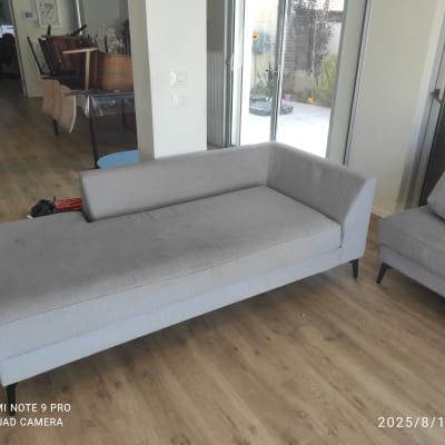 ספה אפורה בחדר עם רצפת עץ