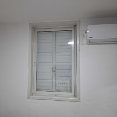 חלון עם תריסים סגורים וקיר לבן